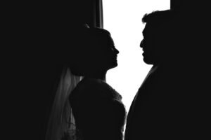 a man and a woman standing in front of a window